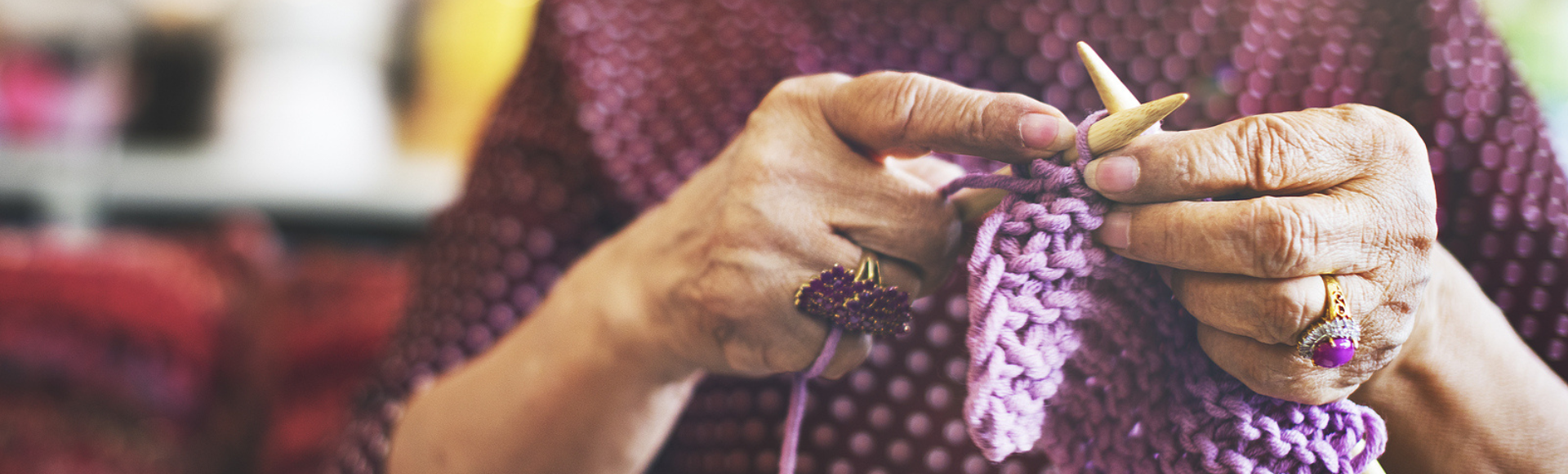 Hands knitting purple scarf